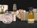 several different types of perfume bottles lined up on a black surface