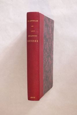 un vieux livre rouge posé sur une surface blanche
