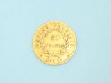 a gold coin on a blue surface with a white background