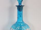 une bouteille en verre bleue ornée d'un motif floral