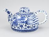 a blue and white teapot with a bird on it