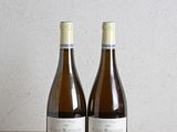 deux bouteilles de vin posées sur une table l'une à côté de l'autre