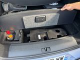 a man that is opening the trunk of a car