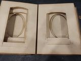 an open book with a picture of two oval windows in it