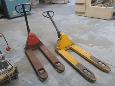 two forklifts sitting next to each other in a warehouse