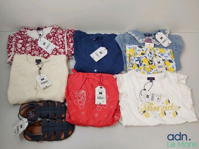 several pairs of baby clothes are laid out on a table
