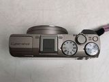 a silver camera with a pink cord attached to it