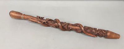 a wooden stick with carvings on it on a white surface