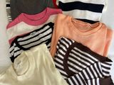 Plusieurs pulls et shorts sont étalés sur un lit