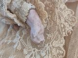 a close up of a doll with a ring on it ' s finger