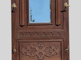 a tall wooden cabinet with a mirror on top of it