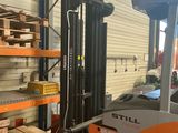a forklift in a warehouse with pallets on the floor