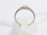 a close up of a diamond ring on a white surface
