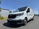 une camionnette blanche garée sur un parking à côté d'un bâtiment