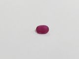 a single pink stone sitting on top of a white surface