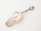 silver plated serving spoon with a handle and handle on a white surface
