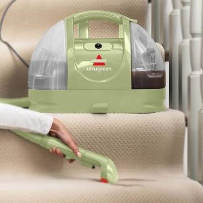 Quelqu'un utilise un aspirateur pour nettoyer les escaliers d'une maison.