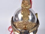 a silver and gold helmet on a wooden base