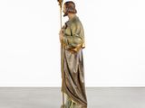 a statue of a man holding a staff in his hand