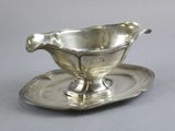 une assiette en argent accompagnée d'une soucoupe posée dessus