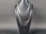 un gros plan d'un collier porté par un mannequin posé sur un présentoir