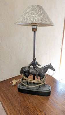 une table sur laquelle se trouvent une lampe et une statue de cheval