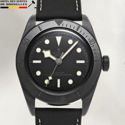 the watch is black with white dots on the face