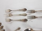 a lot of forks and spoons that are on the table