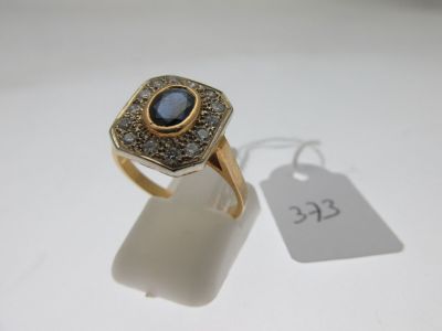 Gros plan sur une bague en or ornée d'une pierre bleue