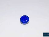 a blue sapphire stone on a white surface