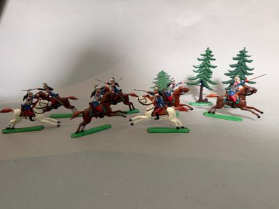 plusieurs figurines représentant des personnes à cheval, alignées, avec des arbres en arrière-plan