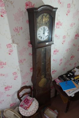 une horloge de parquet dans un coin de la pièce, à côté d'une table
