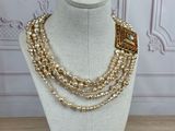a close up of a necklace on a mannequin on a table