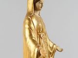 a gold statue of a woman holding a cross