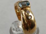 an image of a gold ring with a blue topaz stone in it