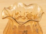 a glass vase with a design on it sitting on a table