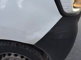 a close up of a car ' s front bumper with a denting on it