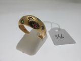 gros plan d'une bague en or sur une surface blanche avec une étiquette de prix