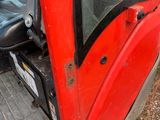 a red tractor that is parked in the dirt
