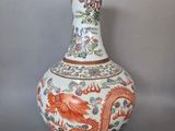 un vase orné d'un dragon, posé sur un socle