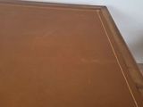 an image of a wooden table with a brown leather top