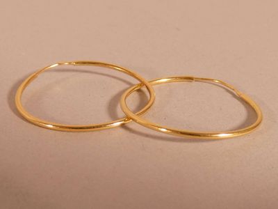 two gold rings sitting on top of each other on a table