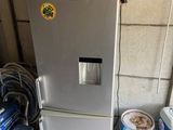 a refrigerator that is next to some buckets of water