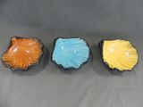 trois petits bols de couleurs différentes sont posés sur une surface grise