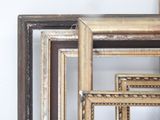 many different frames of different sizes and colors on the wall
