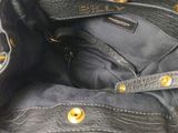a black purse with gold buttons on the inside