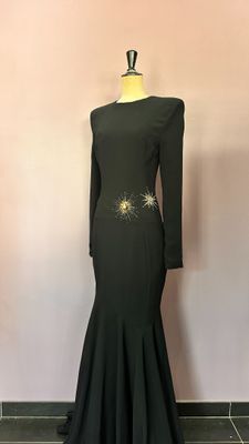 a black dress with gold detailing on the shoulders and shoulders