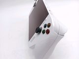 a white game controller sitting on top of a white table