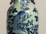 a blue and white vase sitting on a wooden table