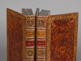 un vieux livre ouvert, laissant apparaître un autre livre avec un marque-page au milieu